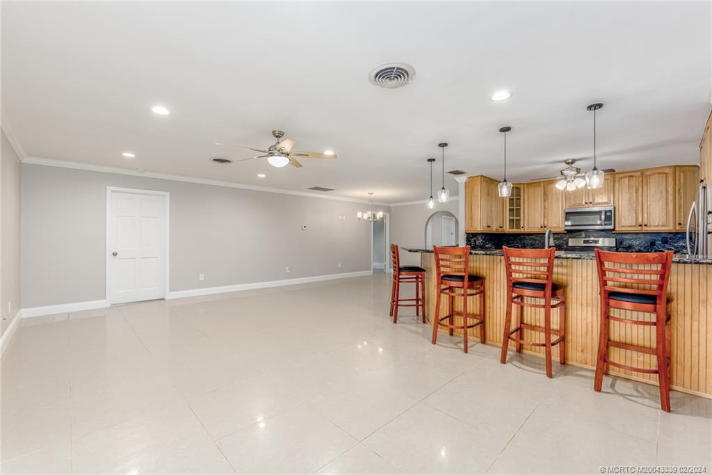 1469 Northwest Fork Road Stuart, FL 34994 - Photo 8 of 39 an open kitchen with granite countertop a stove and white cabinets