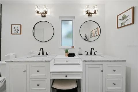 a bathroom with a granite countertop double vanity sink and a mirror