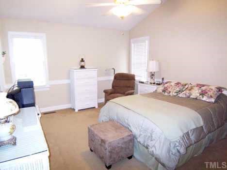 9317 Dawnshire Road Raleigh, NC 27615 - Photo 4 of 9 Nearby, the spacious vaulted MBR features a ceiling fan, neutral carpet, chair rail molding, private Bath & WIC.