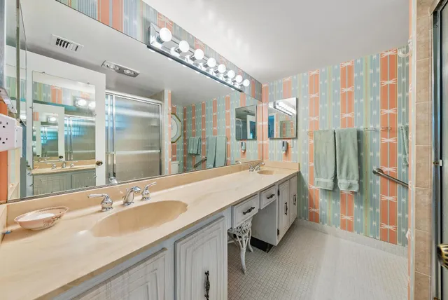 a spacious bathroom with double vanity and a shower