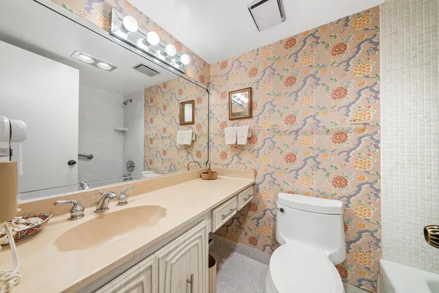 a bathroom with a sink a toilet and shower curtain
