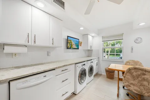 a kitchen with granite countertop white cabinets and white appliances