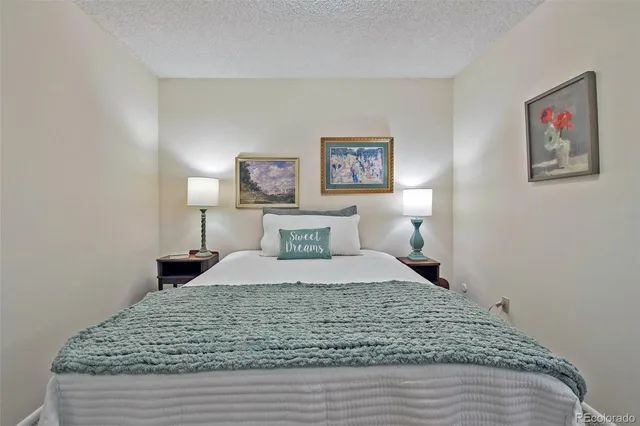 a bedroom with a large bed and a painting on the wall