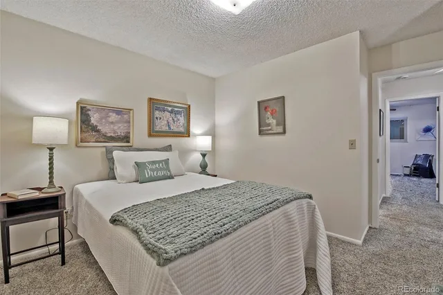 a bedroom with a bed and a painting on the wall