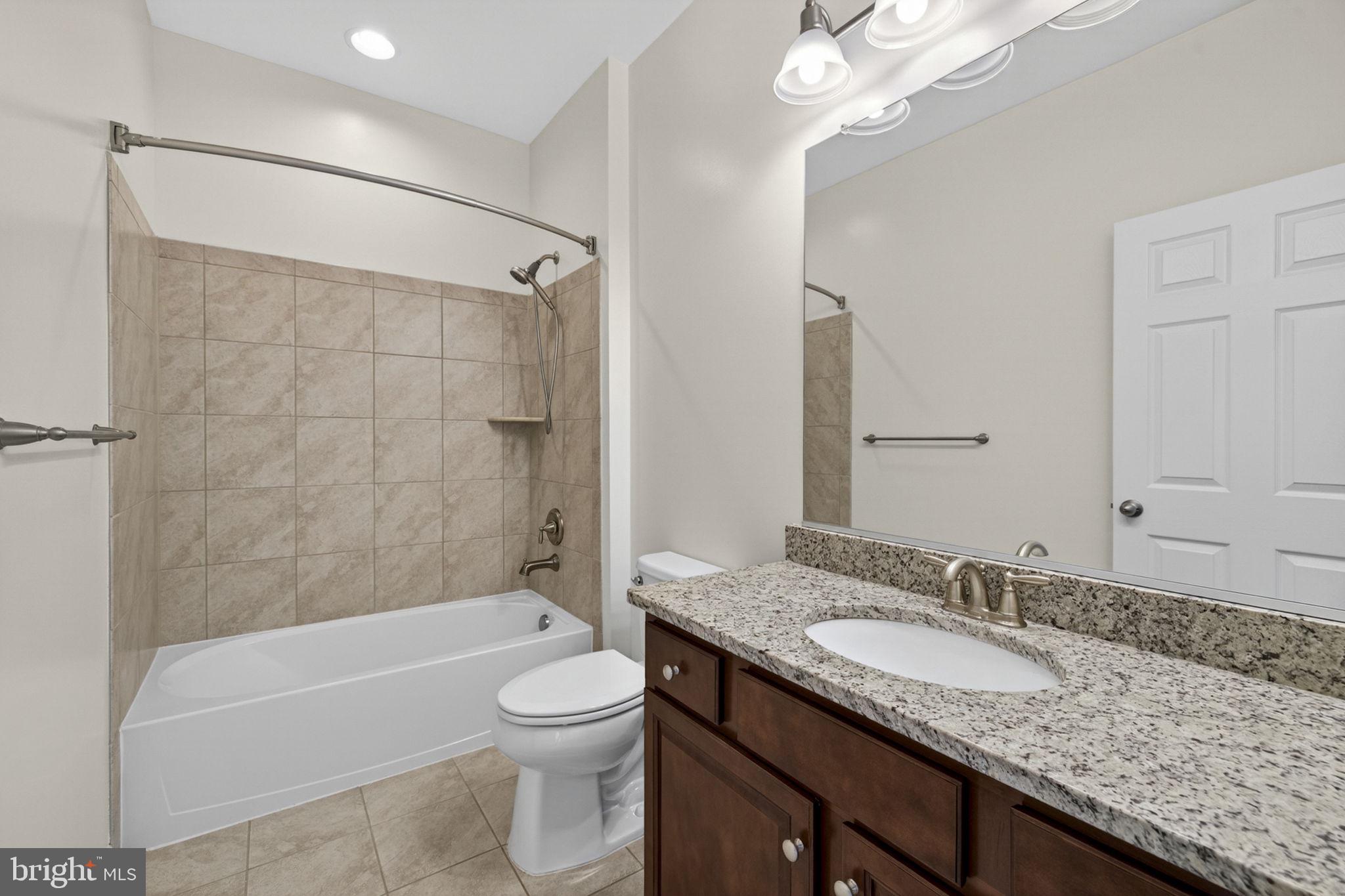 181 Sparkling Brook Road Ranson, WV 25438 - Photo 16 of 101 a bathroom with a granite countertop sink a toilet and bathtub