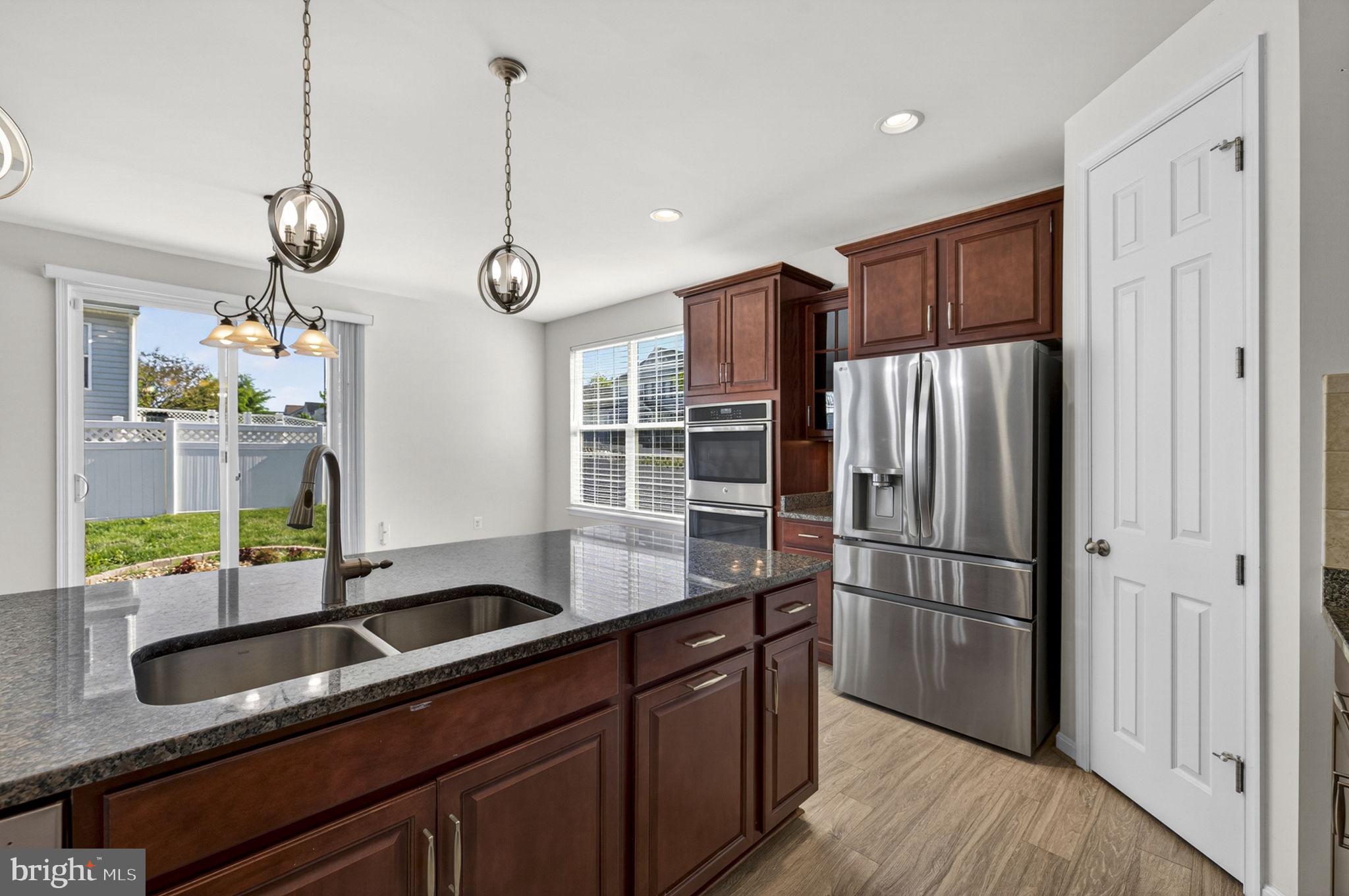 181 Sparkling Brook Road Ranson, WV 25438 - Photo 48 of 101 a kitchen with stainless steel appliances granite countertop a sink a refrigerator and a wooden floor