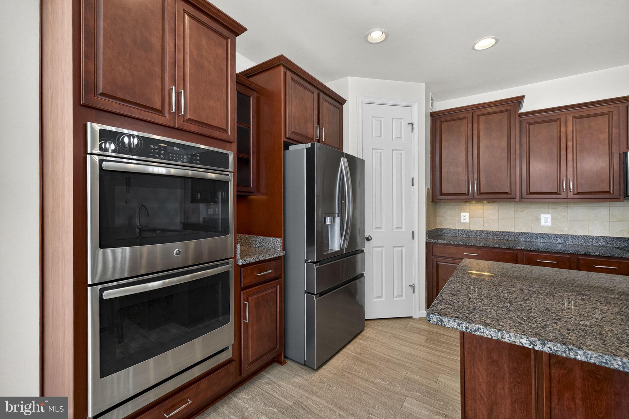 181 Sparkling Brook Road Ranson, WV 25438 - Photo 49 of 101 a kitchen with granite countertop wooden cabinets stainless steel appliances and a counter space