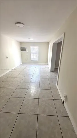 a view of a livingroom with wooden floor and a window