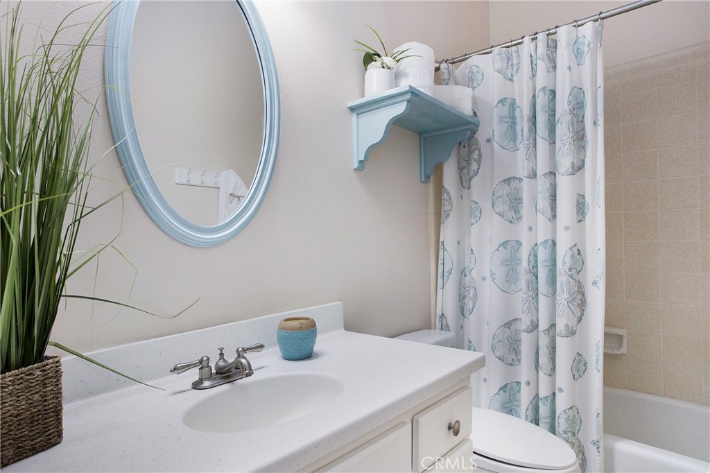 326 17th Street Seal Beach, CA 90740 - Photo 14 of 26 a bathroom with a sink and mirror with toilet