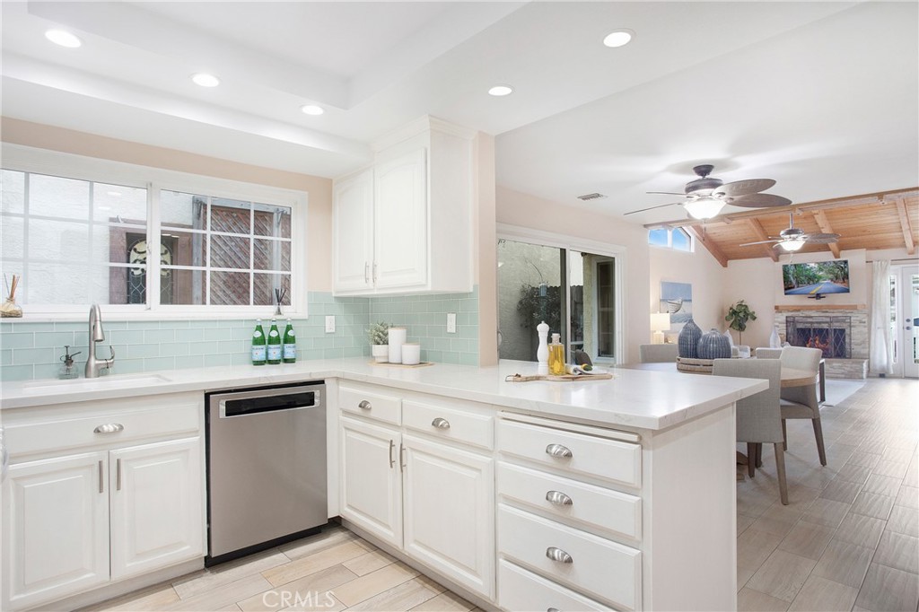 326 17th Street Seal Beach, CA 90740 - Photo 7 of 26 a kitchen with a sink dishwasher and white cabinets with wooden floor