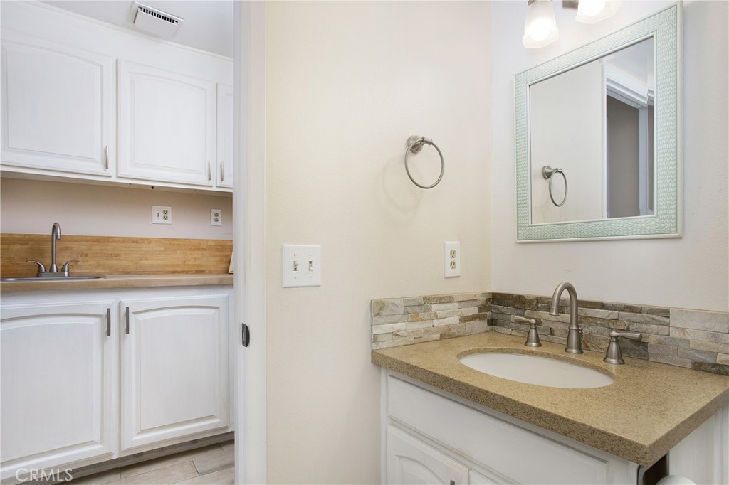 326 17th Street Seal Beach, CA 90740 - Photo 9 of 26 a bathroom with a granite countertop sink and a mirror