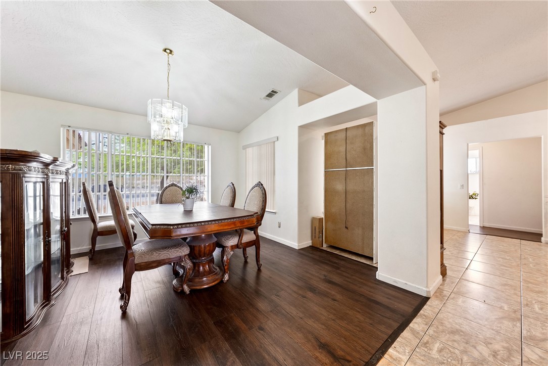 3481 Winery Road Pahrump, NV 89048 - Photo 18 of 34 Dining space featuring lofted ceiling, a chandelier, baseboards, and wood finished floors