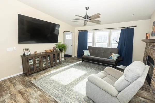 a kitchen with stainless steel appliances a refrigerator a stove a sink dishwasher and white cabinets with wooden floor