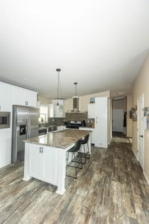 a view of a kitchen with kitchen island dining table and stainless steel appliances