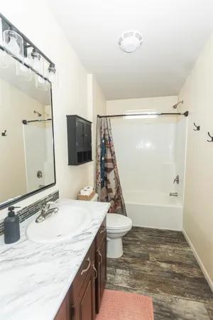 a bedroom with a granite countertop sink and mirror