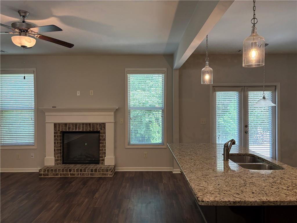 5934 Watersdown Way Flowery Branch, GA 30542 - Photo 8 of 28 a view of an empty room with wooden floor fireplace and a window