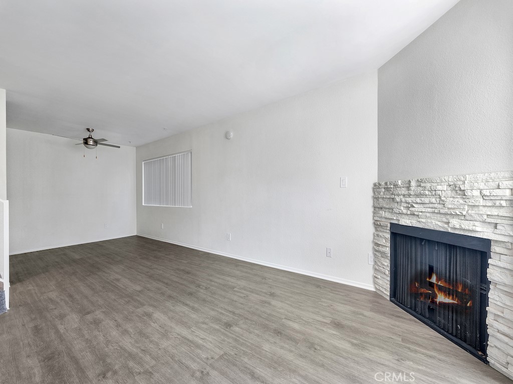 14218 Victory Boulevard Van Nuys, CA 91401 - Photo 7 of 16 an empty room with wooden floor fireplace and windows