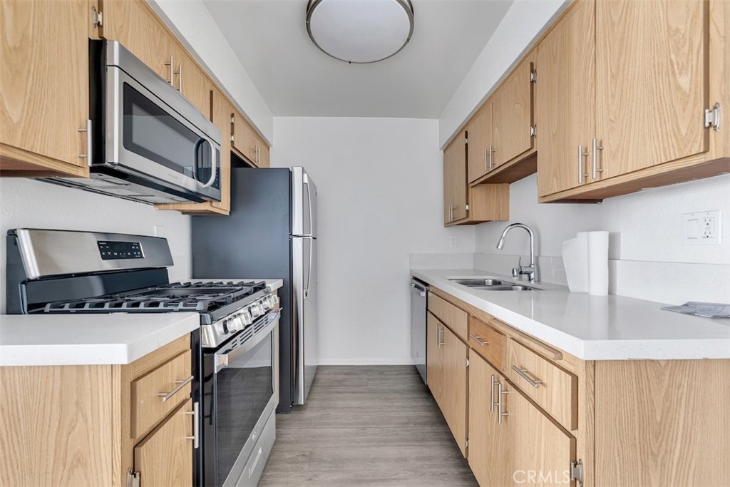 14218 Victory Boulevard Van Nuys, CA 91401 - Photo 10 of 16 a kitchen with stainless steel appliances granite countertop a sink stove and cabinets