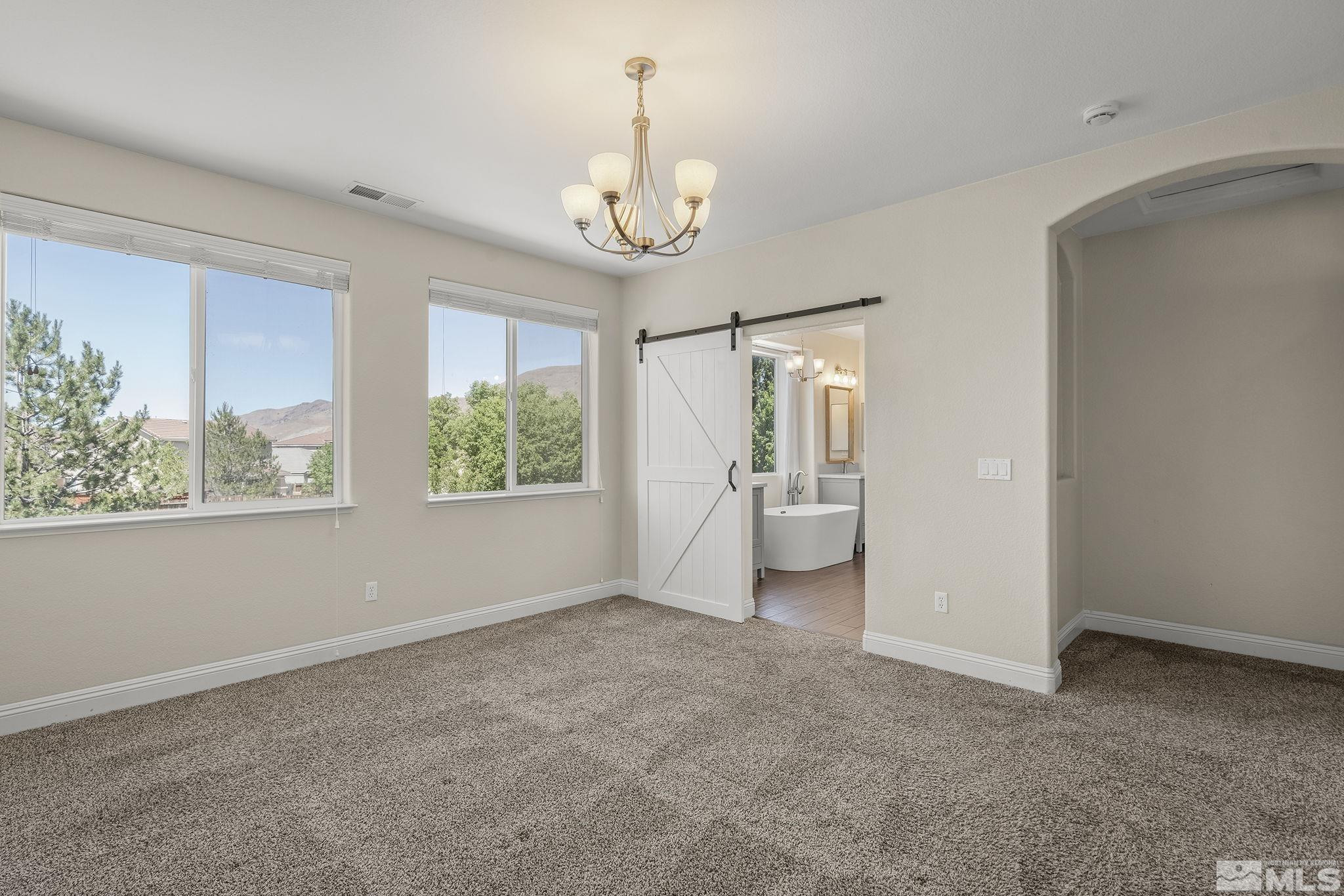 1755 Cavern Drive Reno, NV 89521 - Photo 14 of 25 an empty room with a windows and chandelier