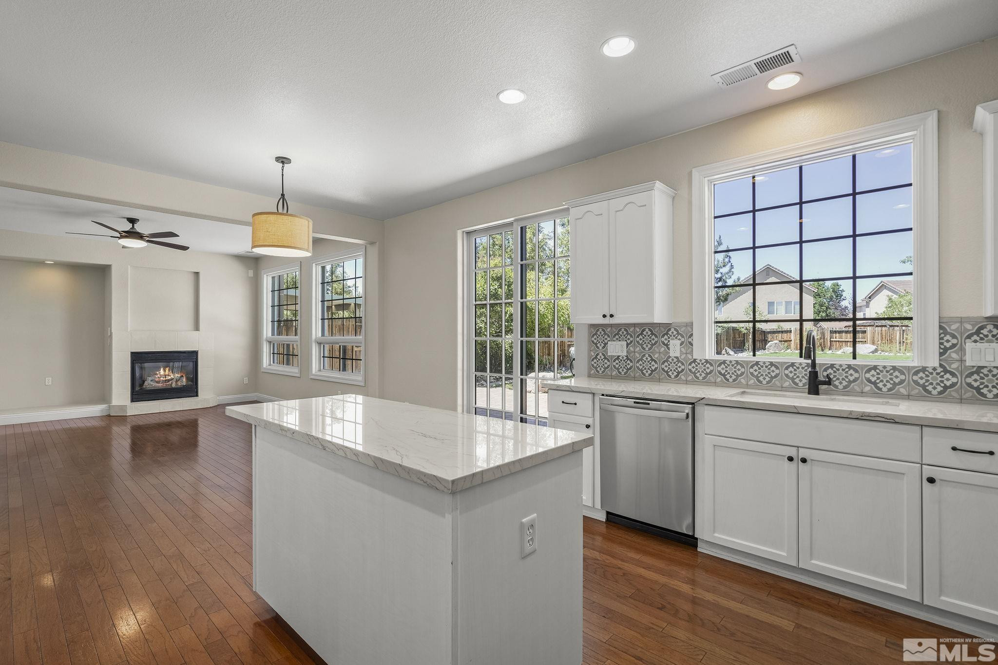 1755 Cavern Drive Reno, NV 89521 - Photo 17 of 25 a large kitchen with granite countertop a large window and white cabinets