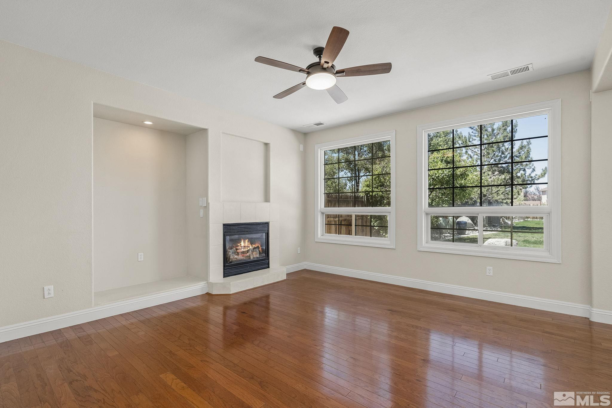 1755 Cavern Drive Reno, NV 89521 - Photo 21 of 25 a view of a livingroom with a fireplace a ceiling fan and wooden floor