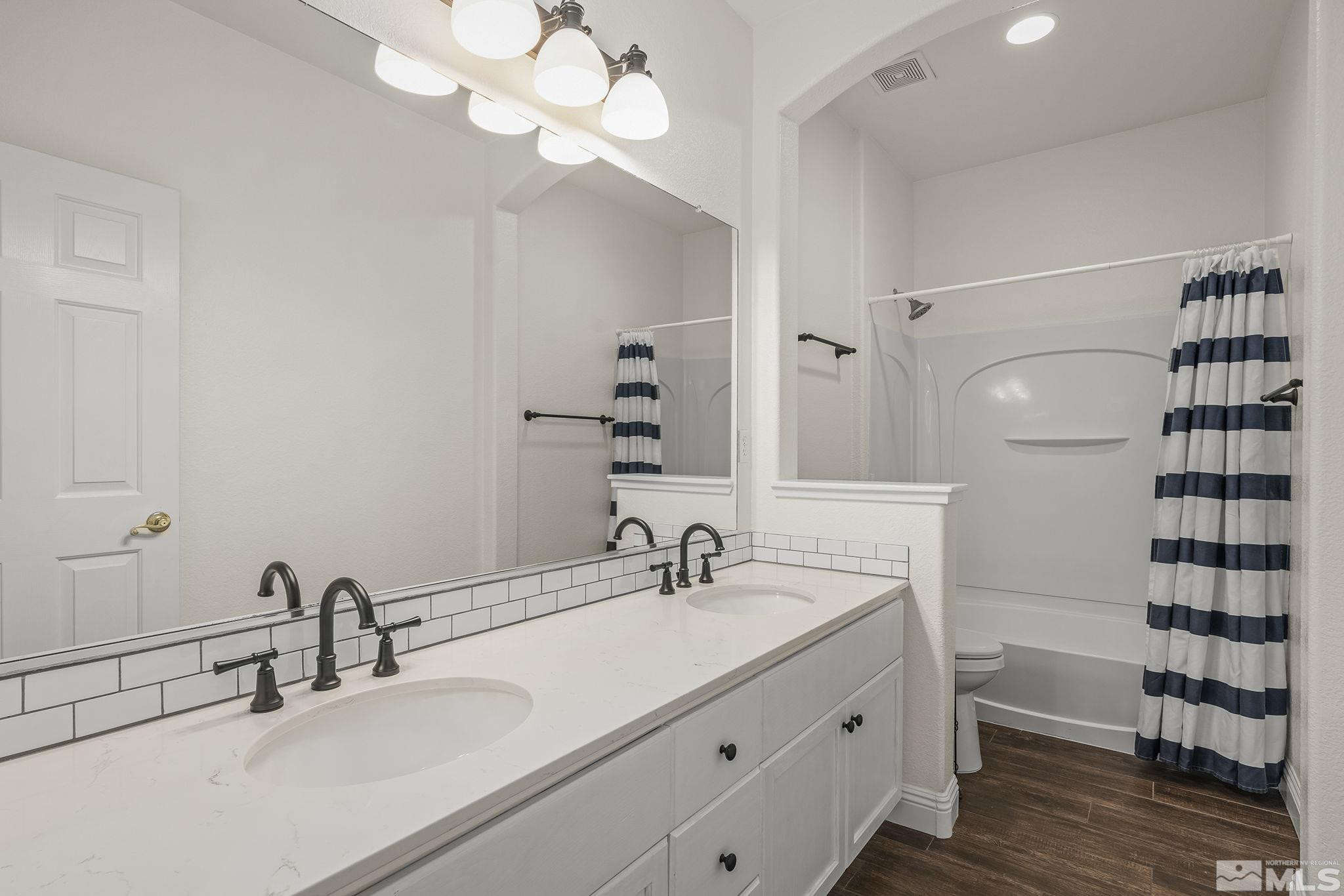 1755 Cavern Drive Reno, NV 89521 - Photo 5 of 25 a bathroom with a sink a toilet and a mirror