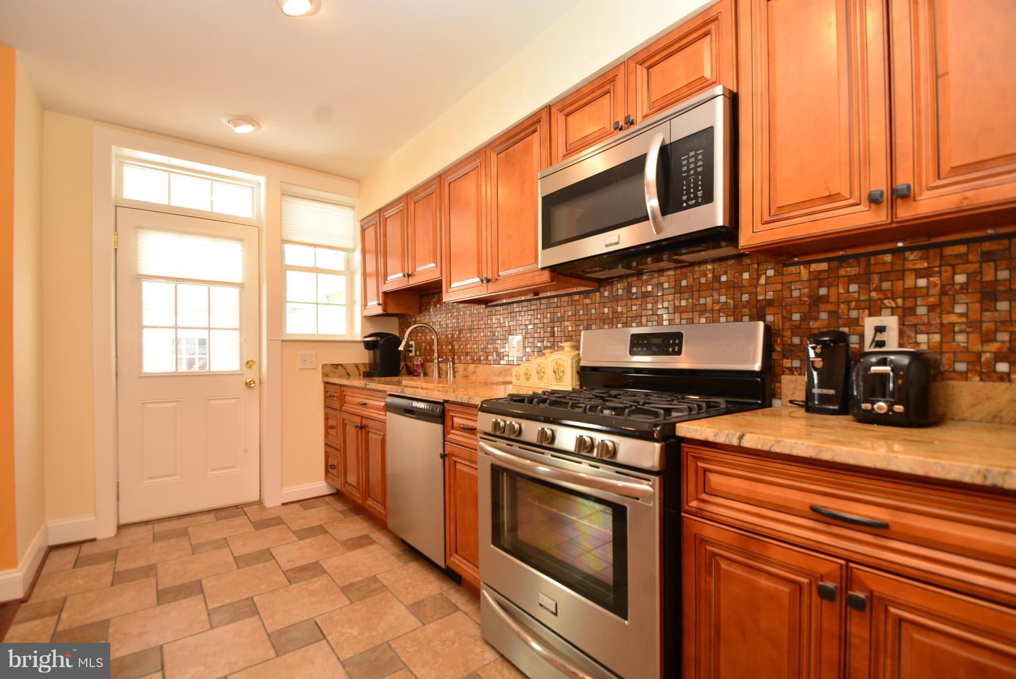 1509 Lochwood Road Baltimore, MD 21218 - Photo 12 of 30 a kitchen with stainless steel appliances granite countertop a stove a microwave and cabinets