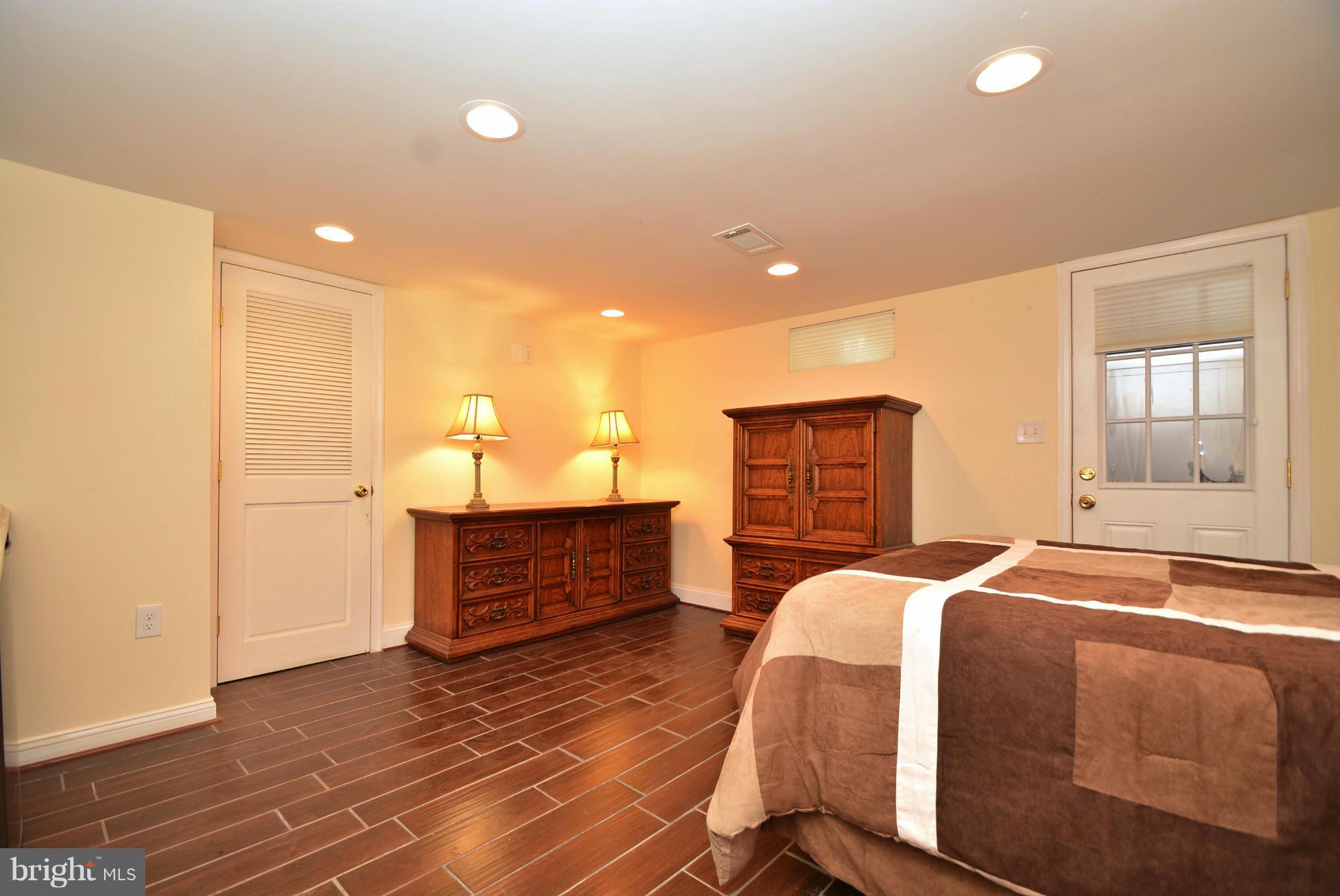 1509 Lochwood Road Baltimore, MD 21218 - Photo 24 of 30 a bedroom with a bed and wooden floor