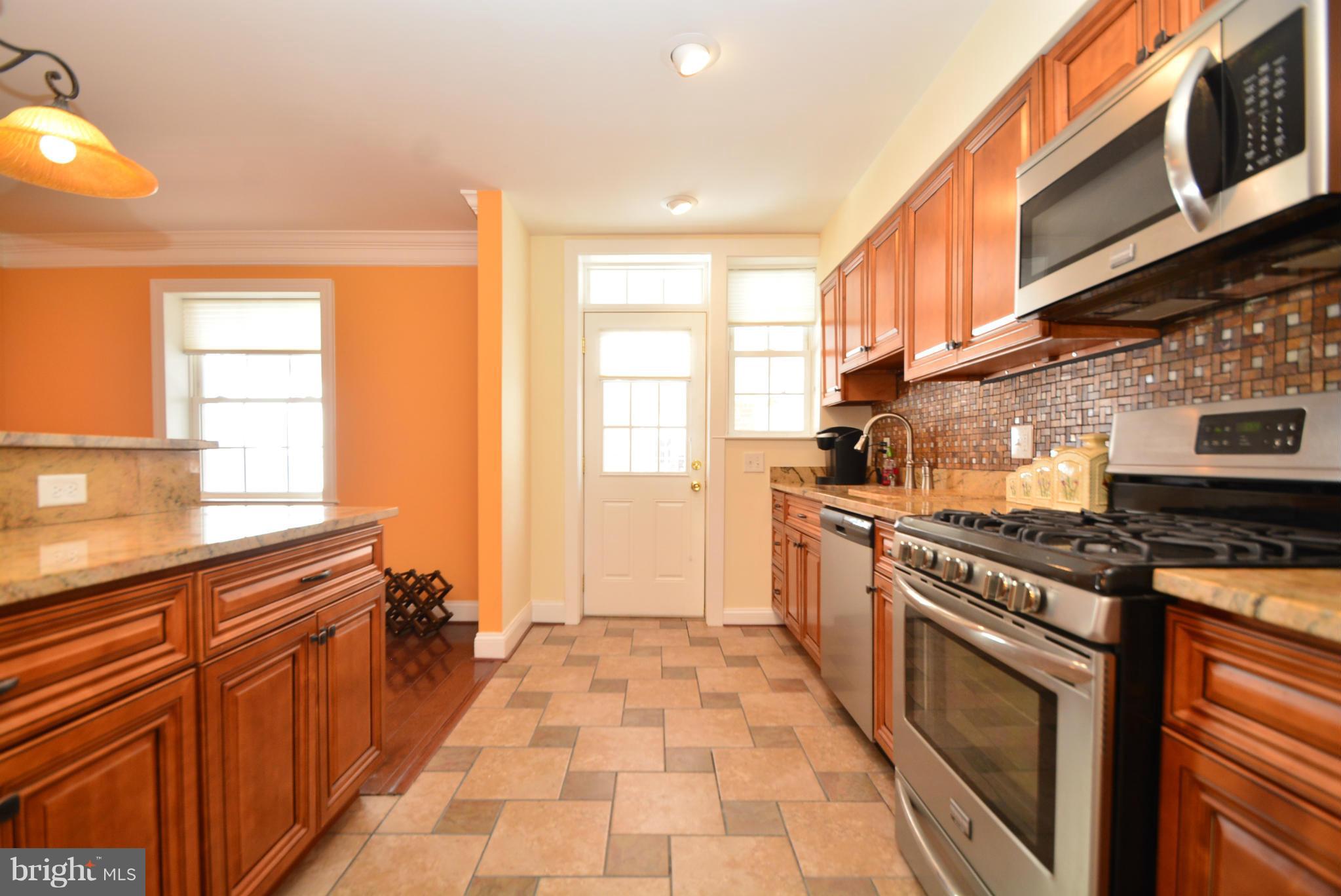 1509 Lochwood Road Baltimore, MD 21218 - Photo 9 of 30 a kitchen with stainless steel appliances granite countertop a stove a sink and a microwave