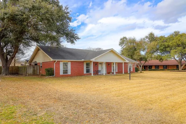 a front of a house with a large tree in front of it