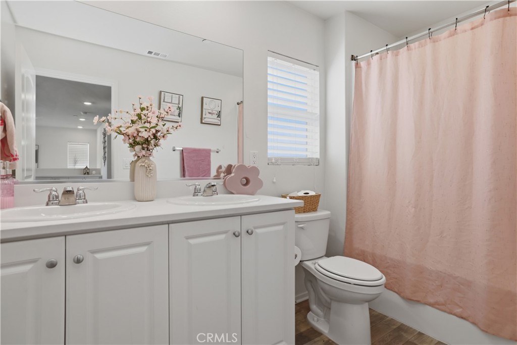 10143 Colten Ridge Adelanto, CA 92301 - Photo 21 of 36 a bathroom with a toilet a sink and mirror