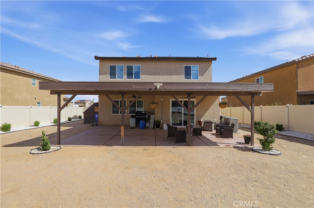10143 Colten Ridge Adelanto, CA 92301 - Photo 28 of 36 a view of a patio with table and chairs a barbeque with wooden fence