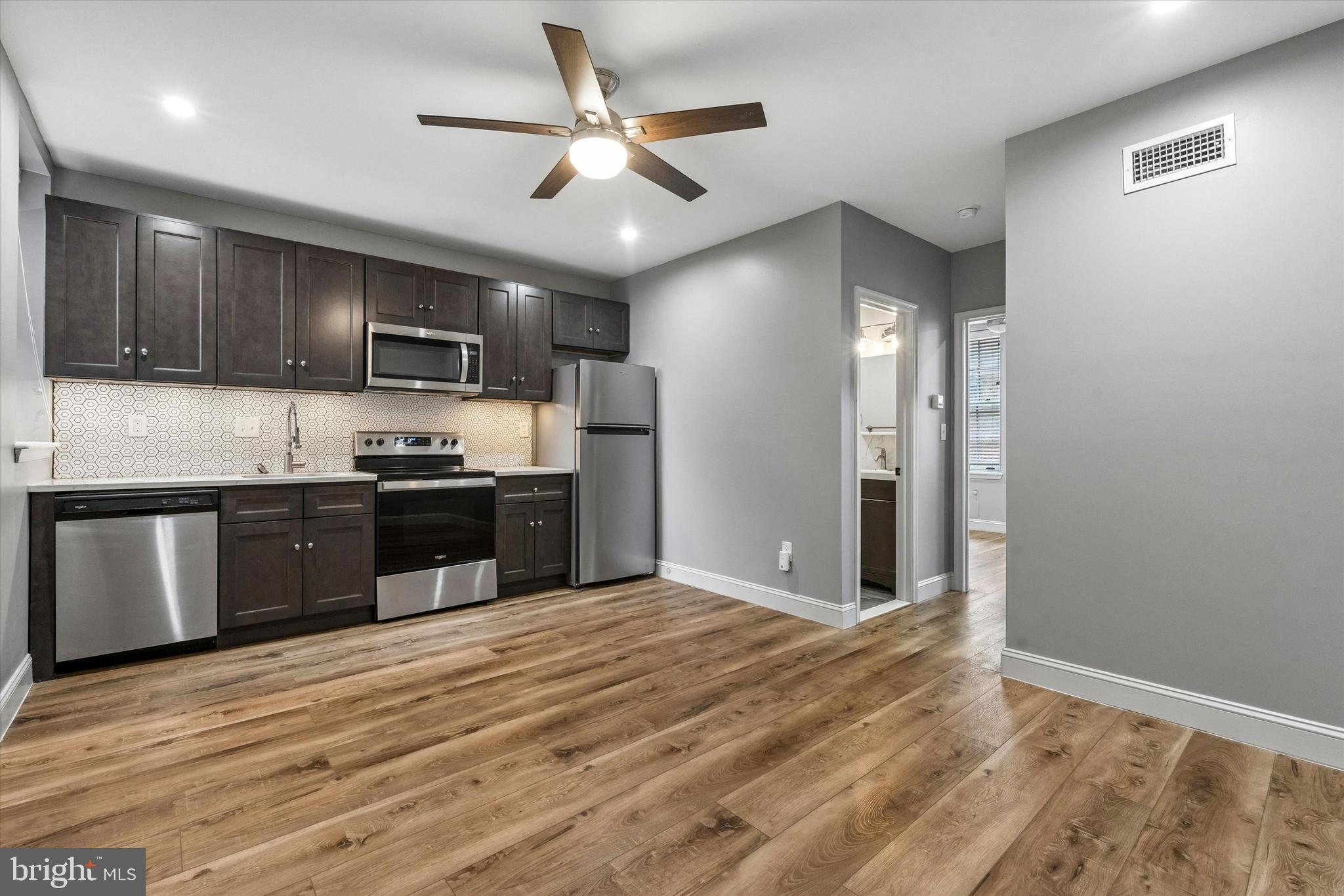 a kitchen with kitchen island granite countertop stainless steel appliances cabinets a sink and a counter top space