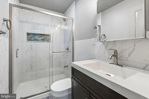 a bathroom with a sink a toilet and shower