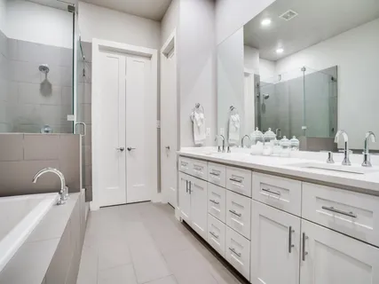 a bathroom with a double vanity sink a mirror and a bathtub