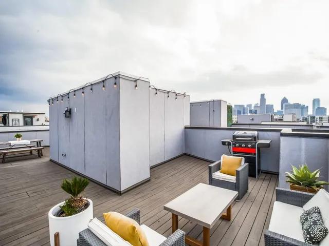 a roof deck with wooden floor and furniture