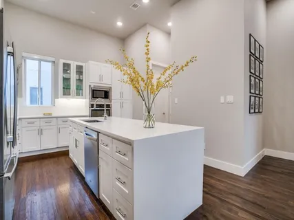 a kitchen with sink stove and wooden floor