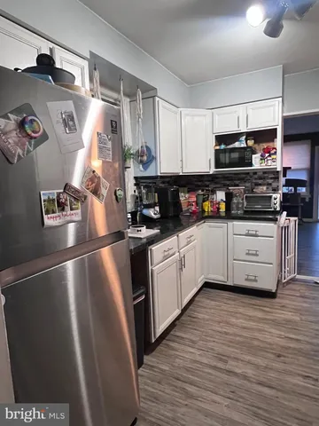 a kitchen with granite countertop a refrigerator and a sink