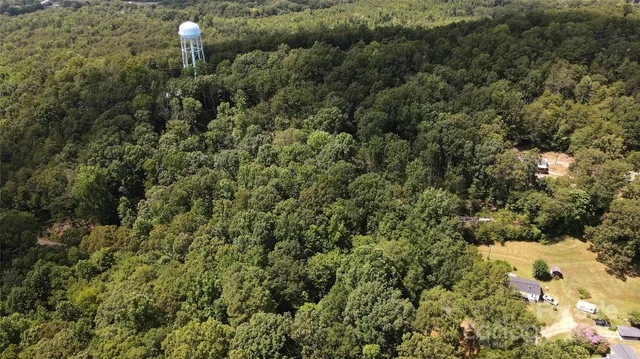 an aerial view of residential house with space and trees all around