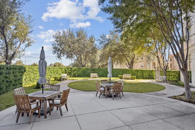 a view of a patio with dining table and chairs with a garden