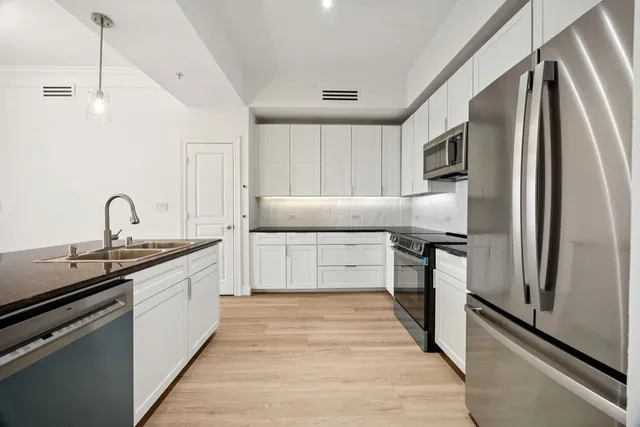 a kitchen with stainless steel appliances a sink and a refrigerator