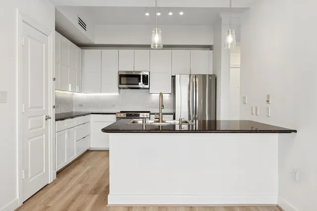 a kitchen with stainless steel appliances a sink and a refrigerator
