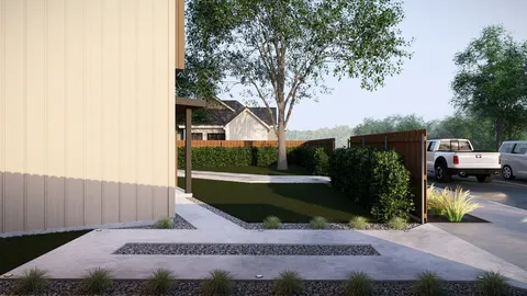 a view of a house with a small yard plants and large tree