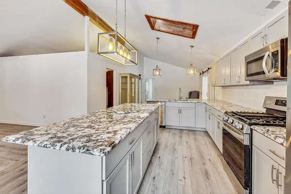 a kitchen with stainless steel appliances granite countertop a stove and a sink
