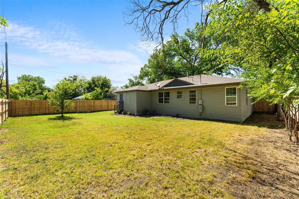 612 East 8th Street Kemp, TX 75143 - Photo 5 of 25 Spacious backyard featuring a full perimeter wood privacy fence, a mature tree, and a small sapling