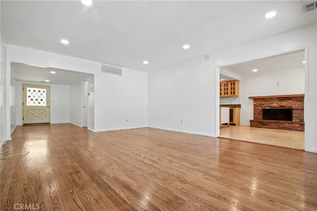 an empty room with wooden floor and fireplace
