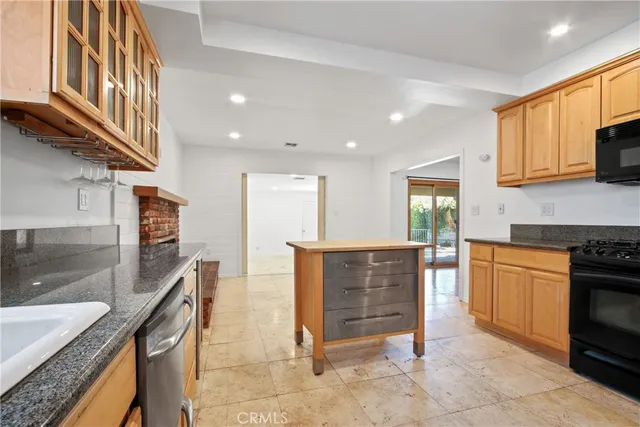 a kitchen with stainless steel appliances granite countertop a sink a stove and a refrigerator