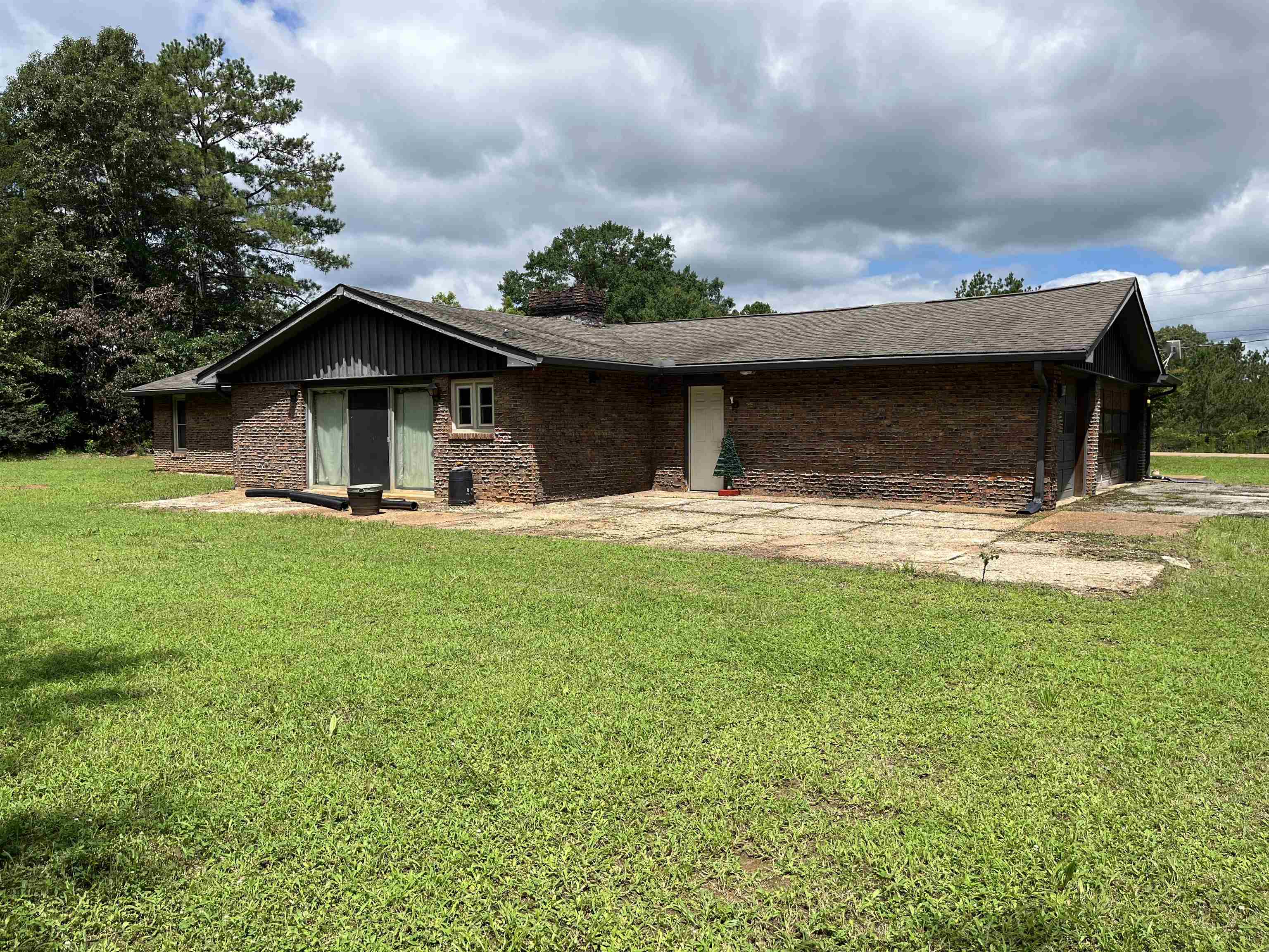 1125 Tyson Road Toone, TN 38381 - Photo 3 of 12 Brick exterior with a dark shingle roof and a concrete patio
