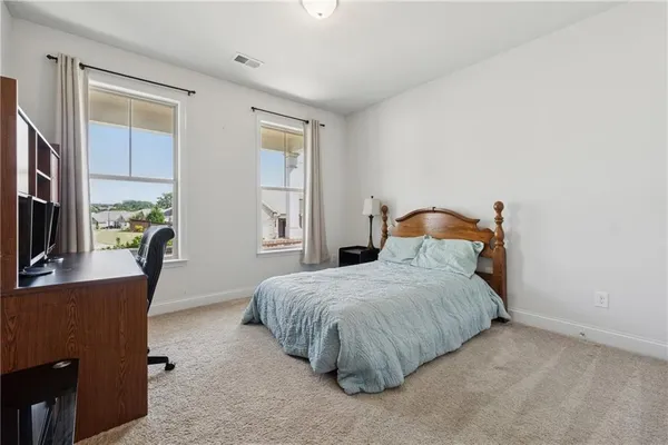 a bedroom with a bed a window and dresser