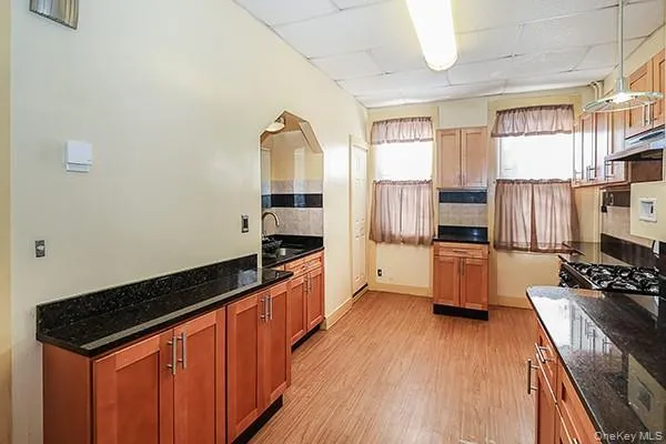 a kitchen with stainless steel appliances a refrigerator a stove a sink and white cabinets